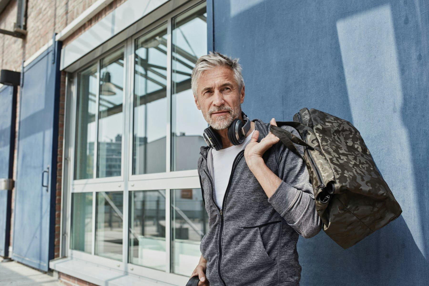 headphones portrait man gym sports bag camouflage adults people fitness sport workout best ager healthy lifestyle fashionable active on shoulders men's fashion mature men one person 55-60 years caucasian grey hair beard sportive healthy exercising fit leisure motivation training building outdoors day waist up patterned sportswear activity tracksuit top health awareness lifestyle germany health fashion 50-60 years mature adults built structure pattern tracksuit photography color image person adult male electronics bag handbag accessories