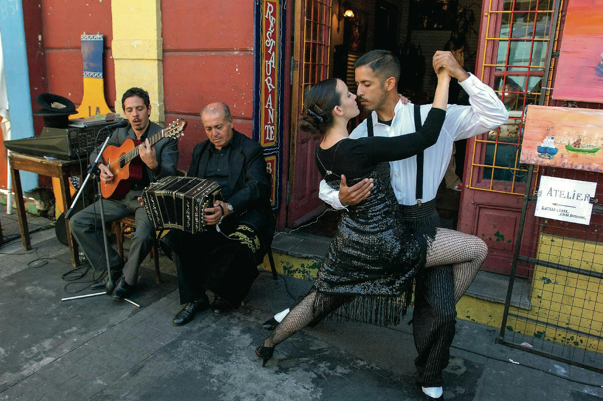 Tango šokėjai Buenos Airių La Bocos rajone. Šiam šokiui akompanuojama skirtingas kultūrines tradicijas vienijančiais muzikos instrumentais.